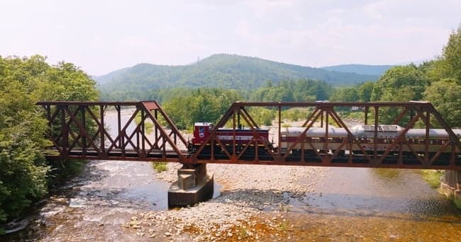 Historic railroad bridge spanning a quiet river in green hills