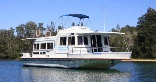 Spacious luxury houseboat moored on serene river with eucalyptus banks