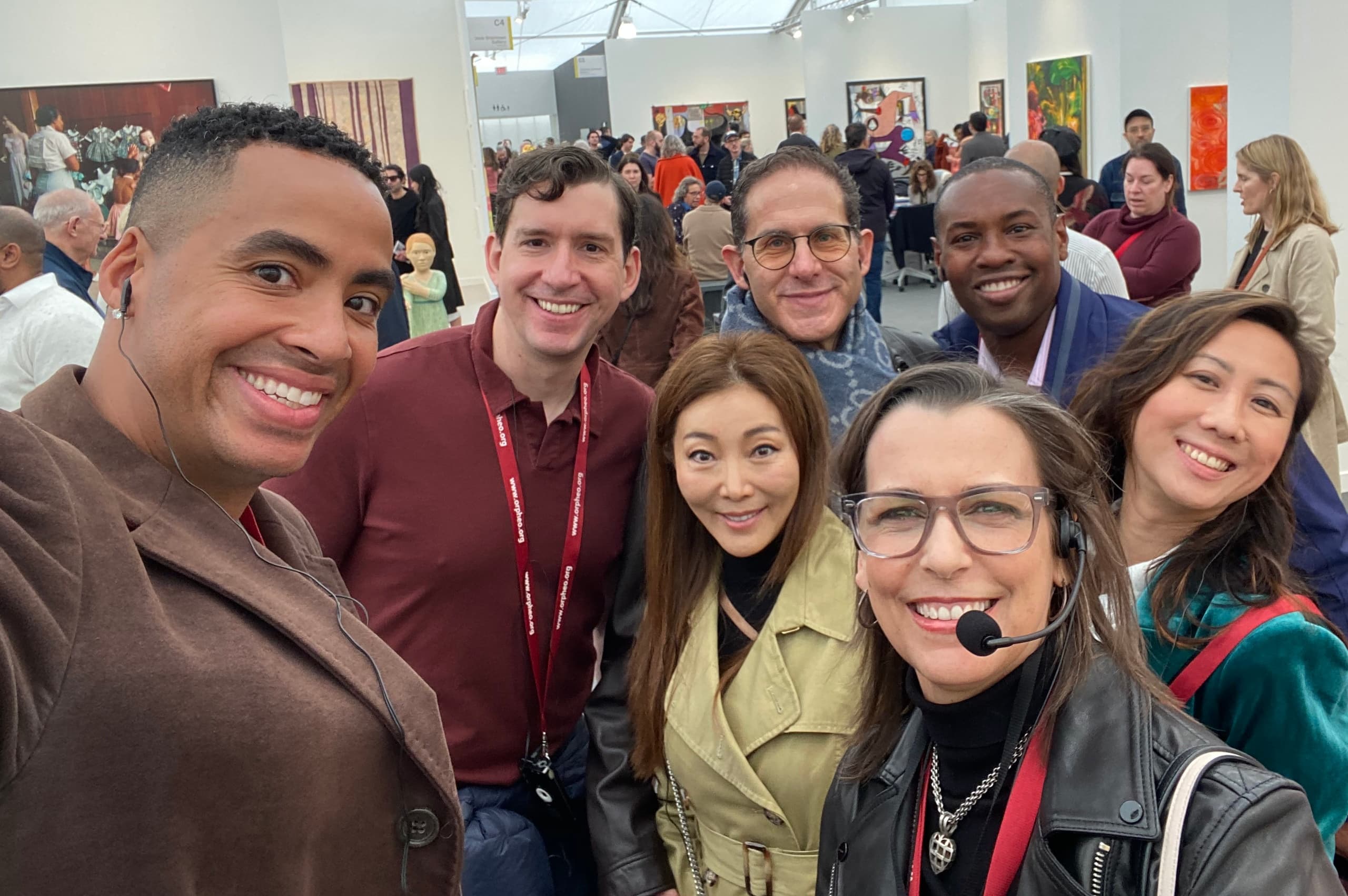 Group selfie of visitors inside modern art gallery at exhibition