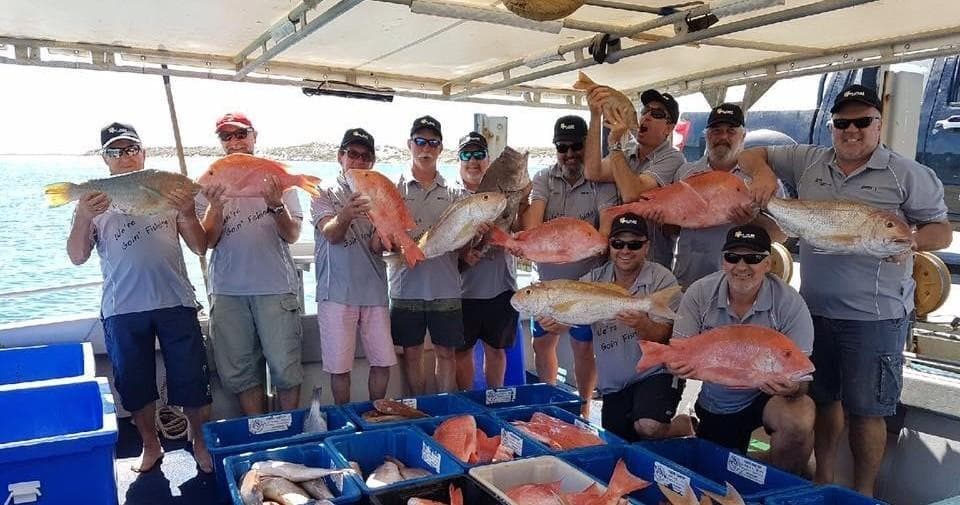Fishing crew posing with multiple snappers aboard offshore charter