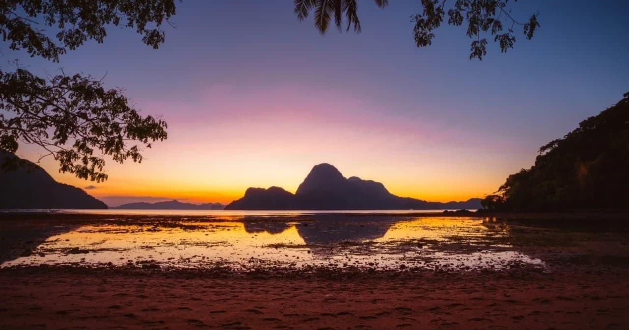 Sunset over Hinchinbrook Island silhouette with tidal reflection