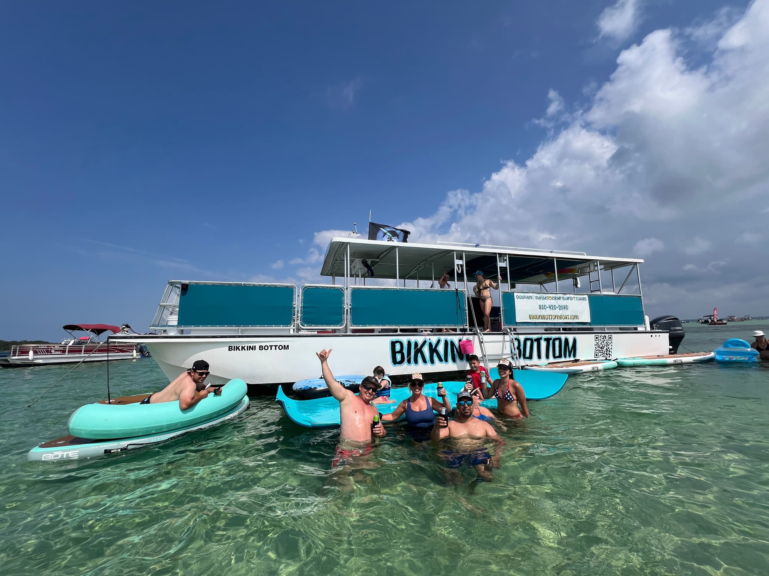 Guests swimming beside tour boat in clear shallow tropical water