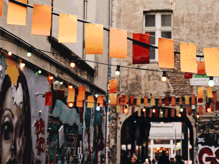 Paper lanterns over graffiti-lined Berlin alley during street festival