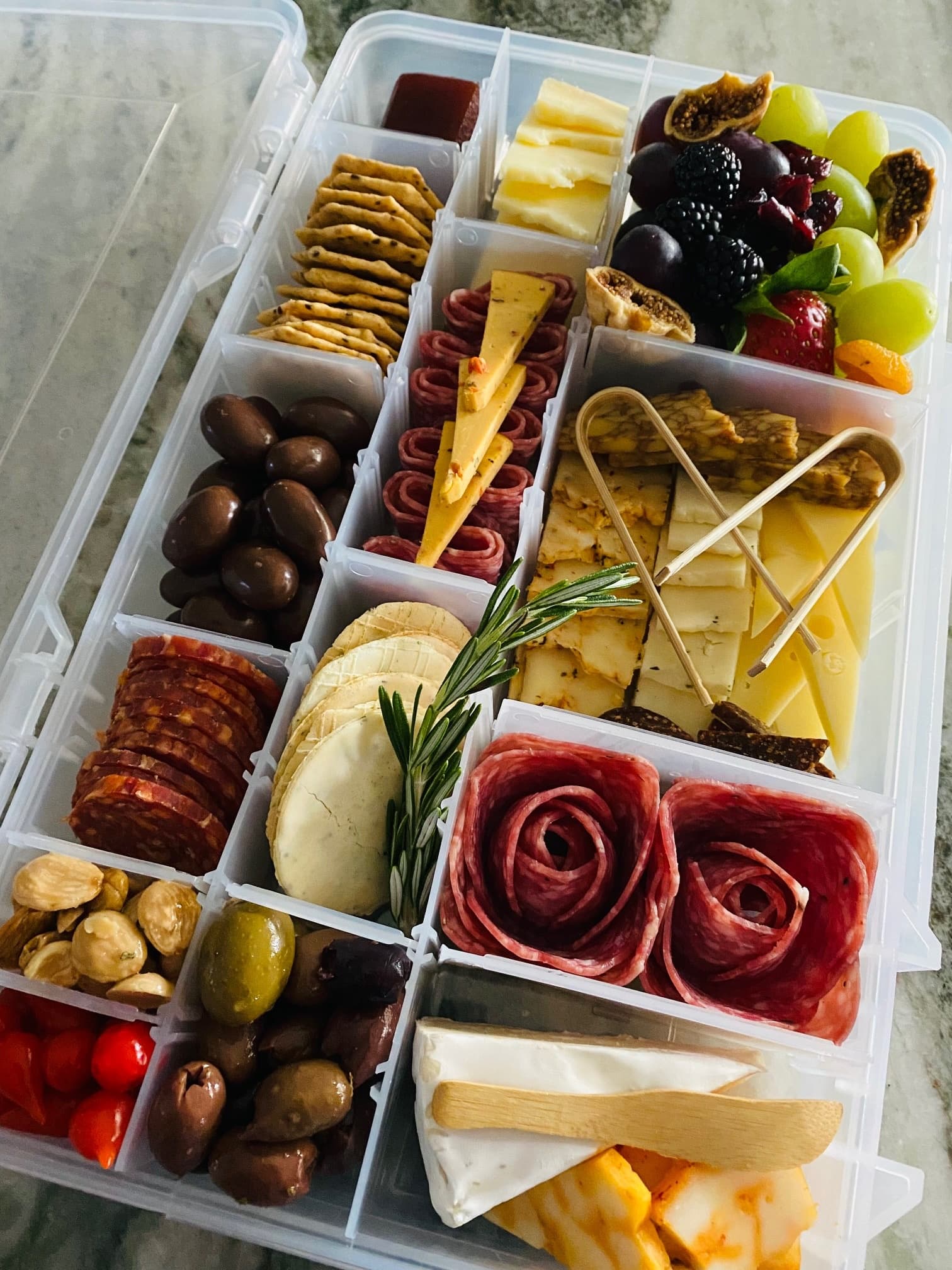 Portable charcuterie box with cheeses, fruits and crackers