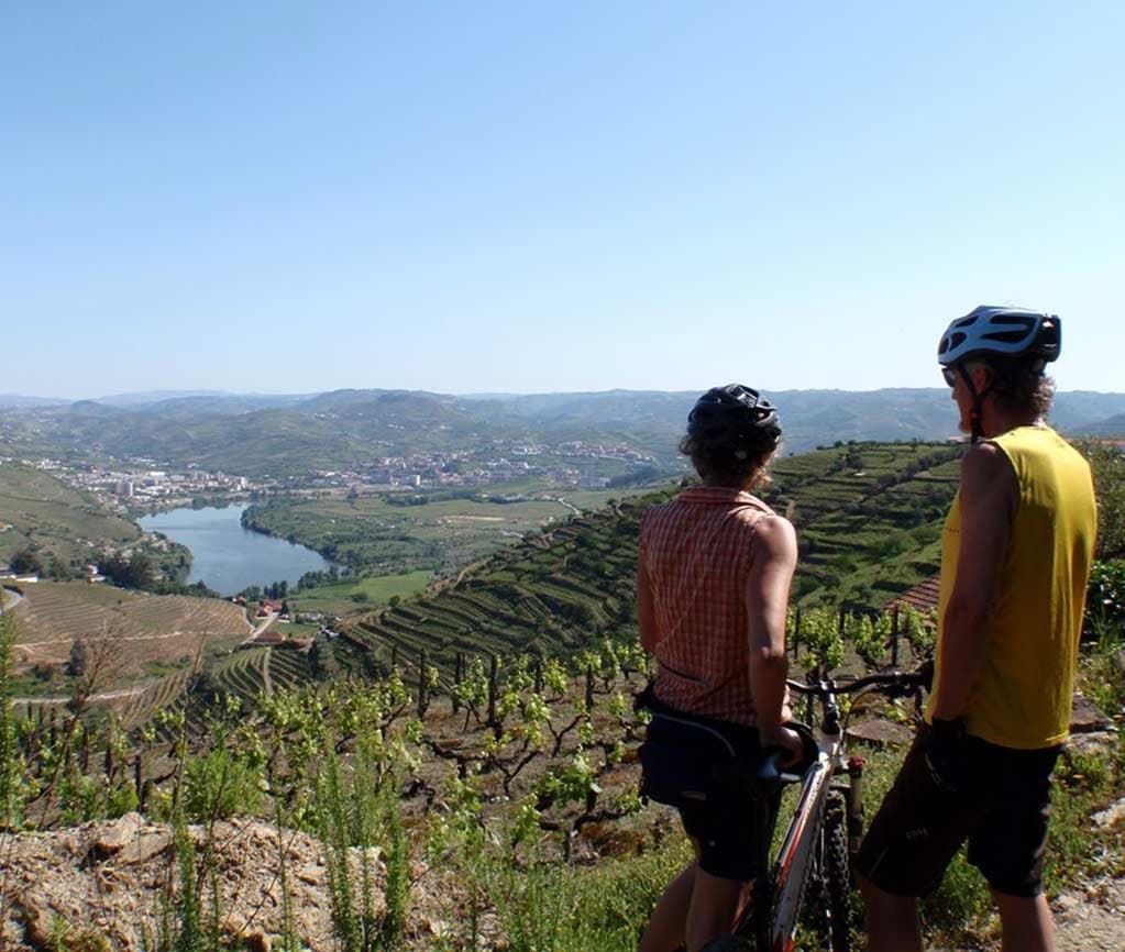 Cyclists stopping to admire terraced valley and river