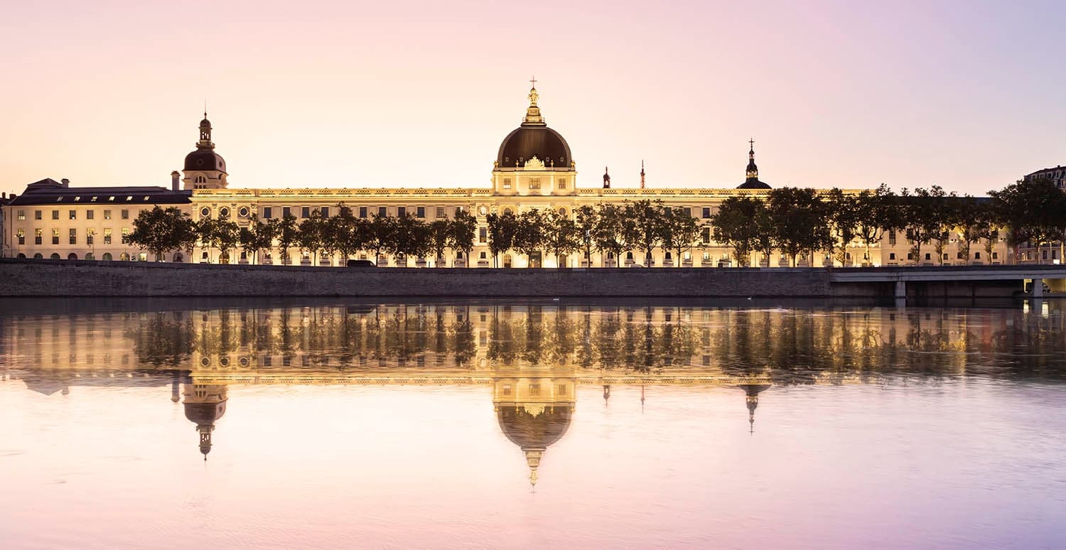 Riverside sunset reflection of grand building, scenic waterfront