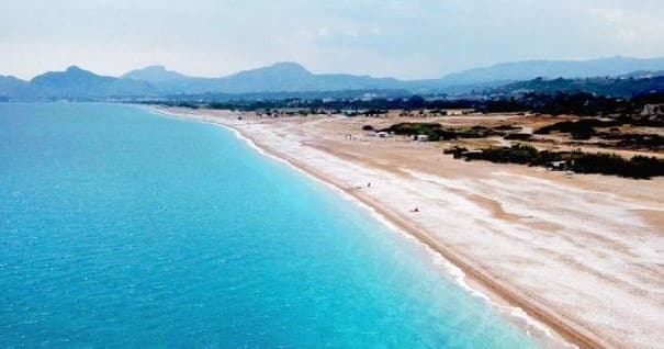 Aerial view of turquoise beach near Rhodes coastline, scenic shore