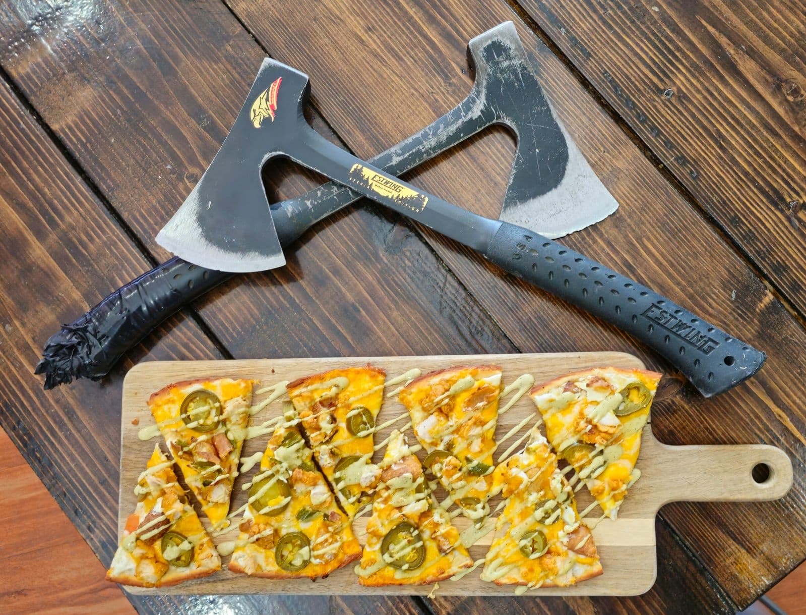 Axes and flatbread on wooden board, axe pub food presentation