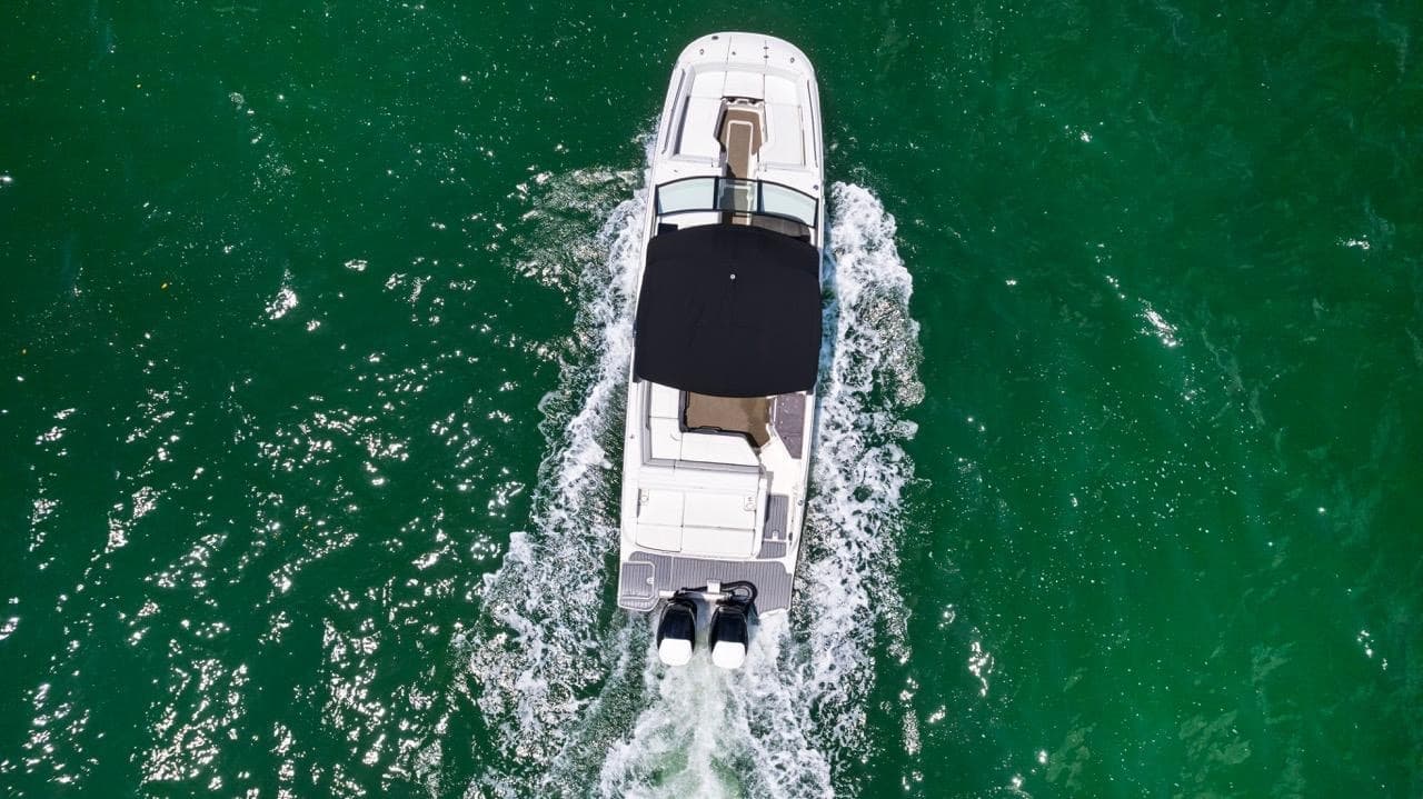 Aerial view of powerboat cutting through emerald ocean