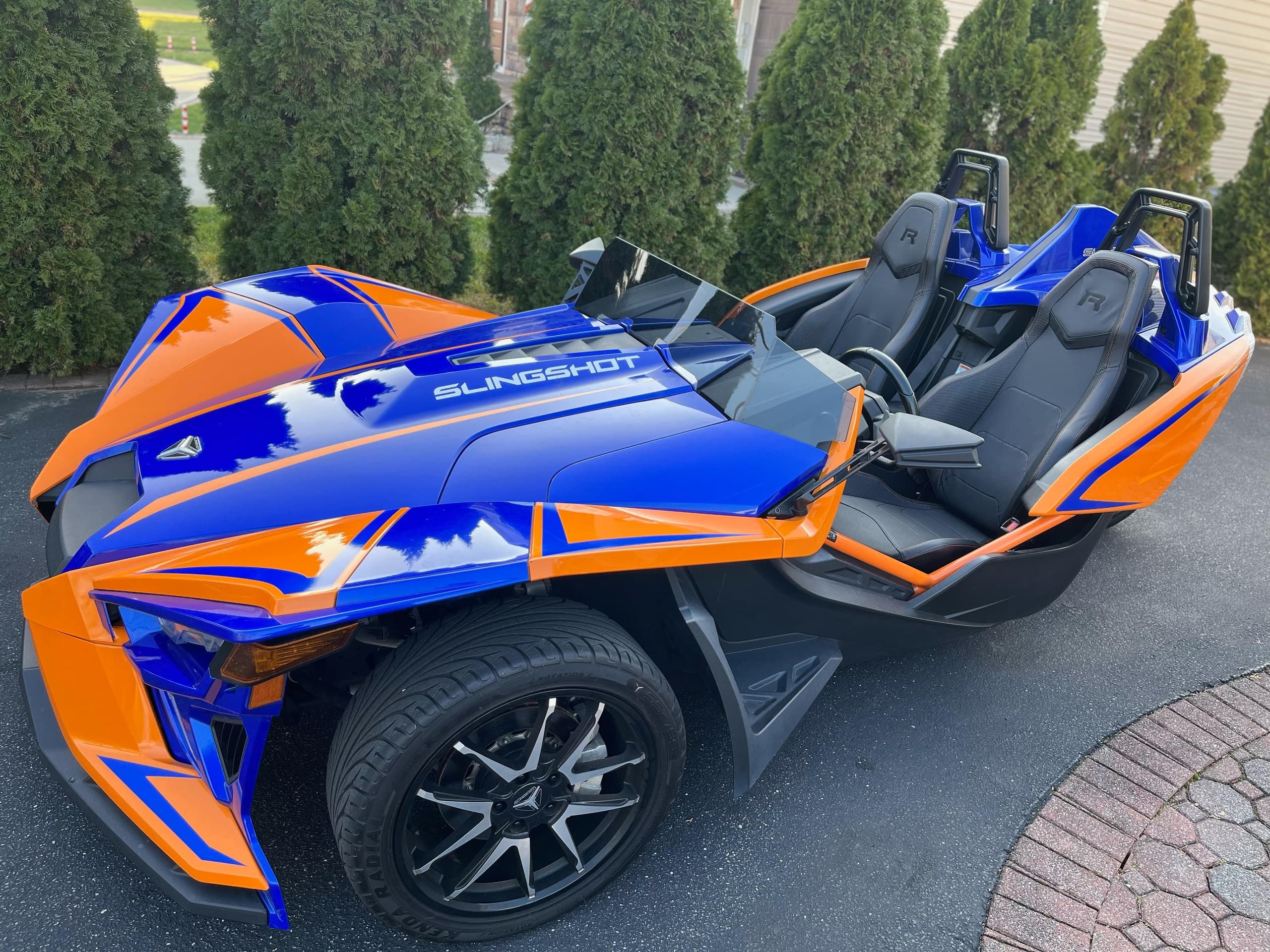 Blue orange Slingshot parked in suburban driveway ready to ride