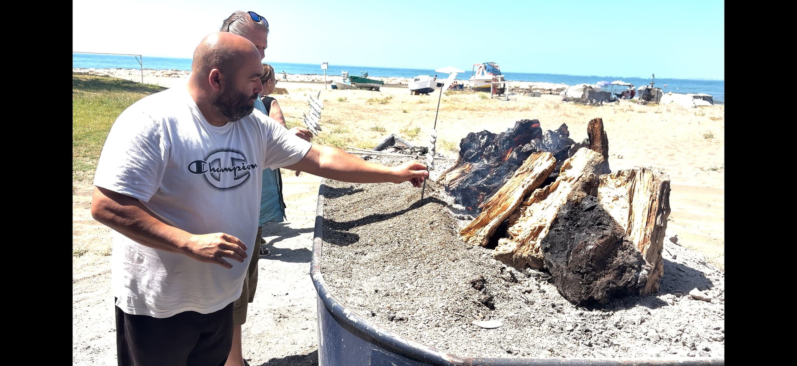 Beachfire cooking with guide grilling fish, coastal outdoor meal