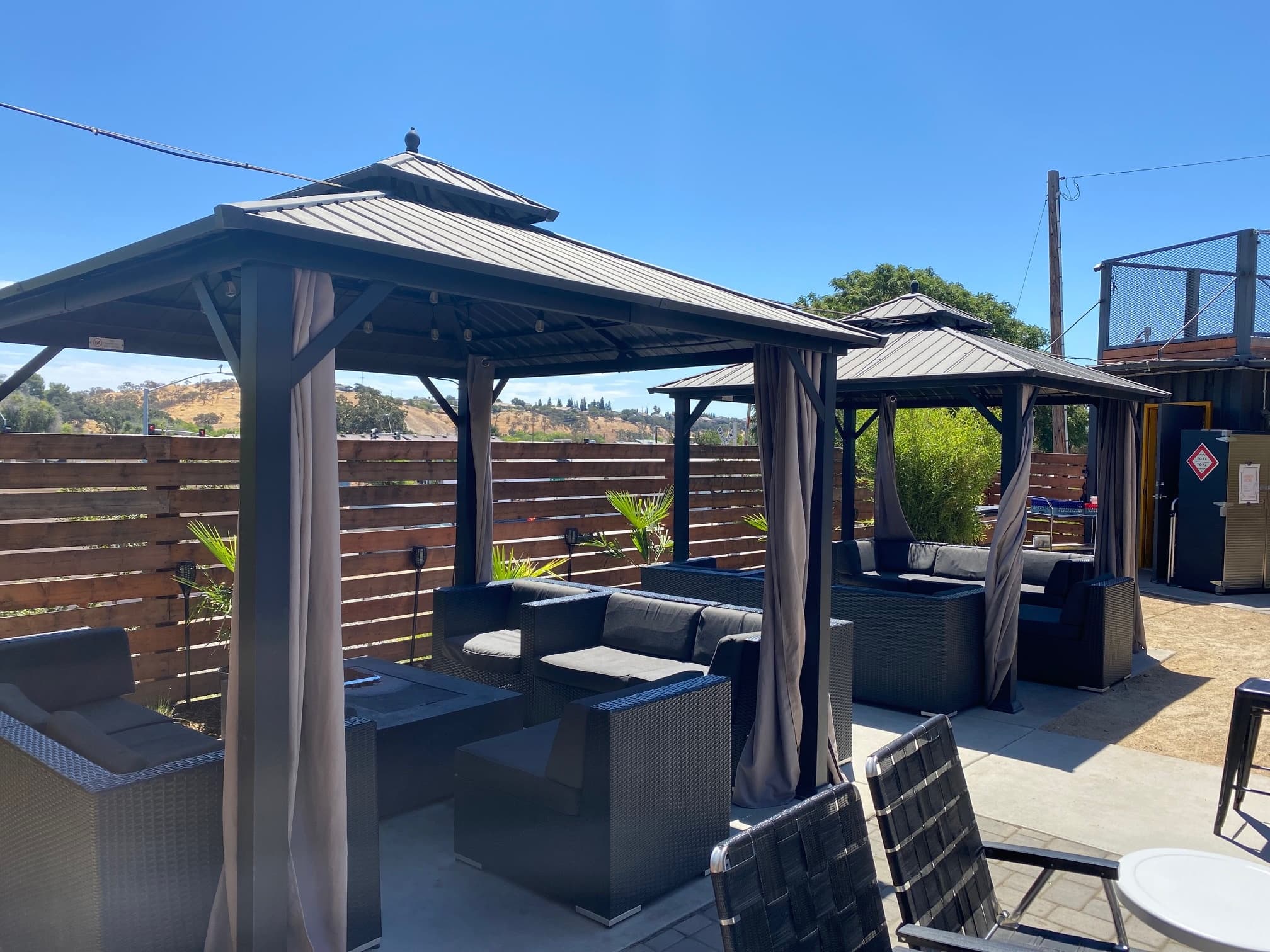Shaded gazebo seating area at sunny outdoor beer garden patio