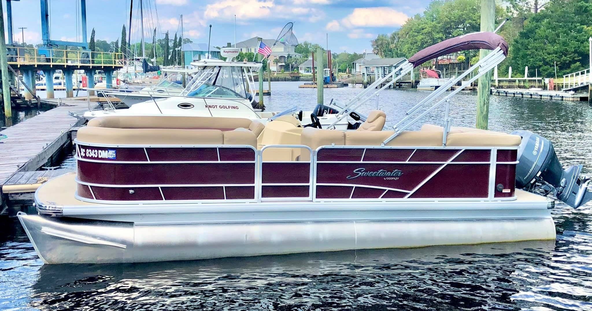 Pontoon boat charter docked at marina for scenic lake cruises