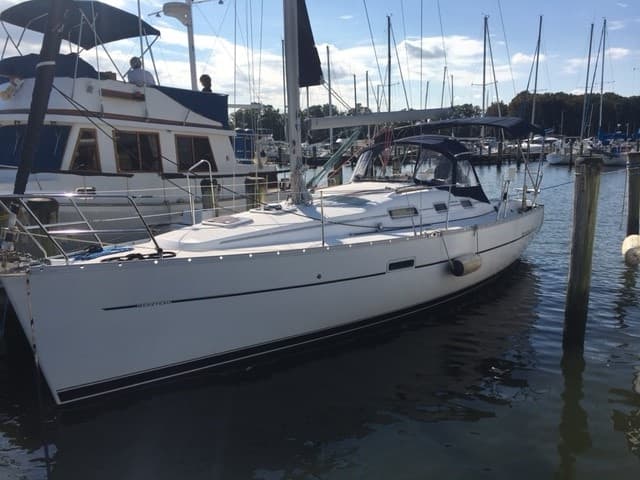 White yacht docked at marina with moored boats, calm harbor