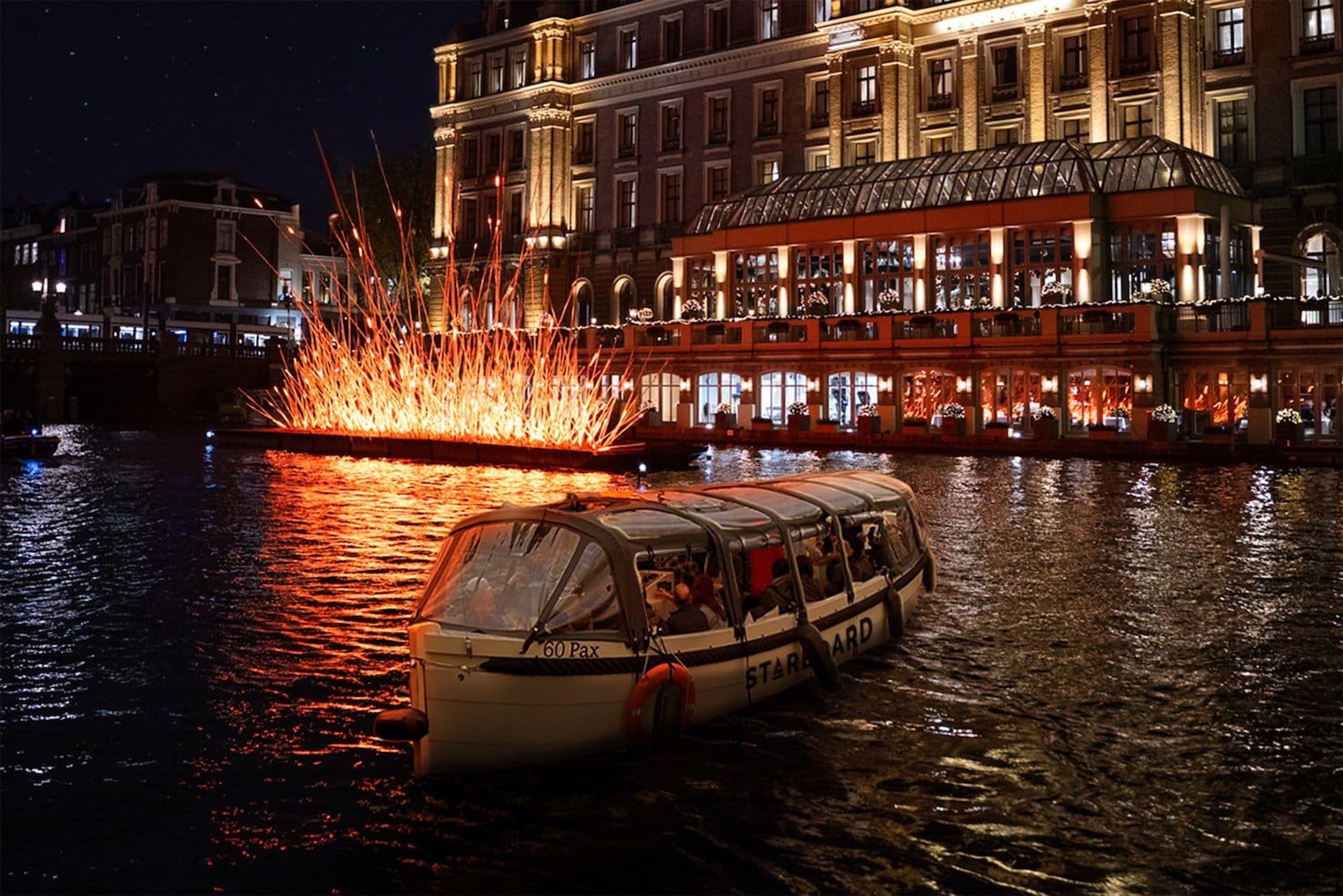Night-time canal cruise with sparks and illuminated city lights