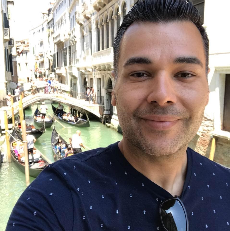 Traveler smiling on gondola amid Venice canals, urban waterways