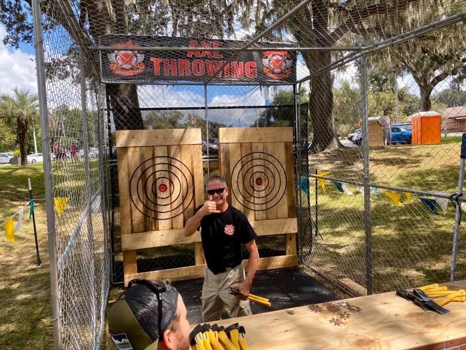 Outdoor axe throwing booth with wooden targets at Ocala event