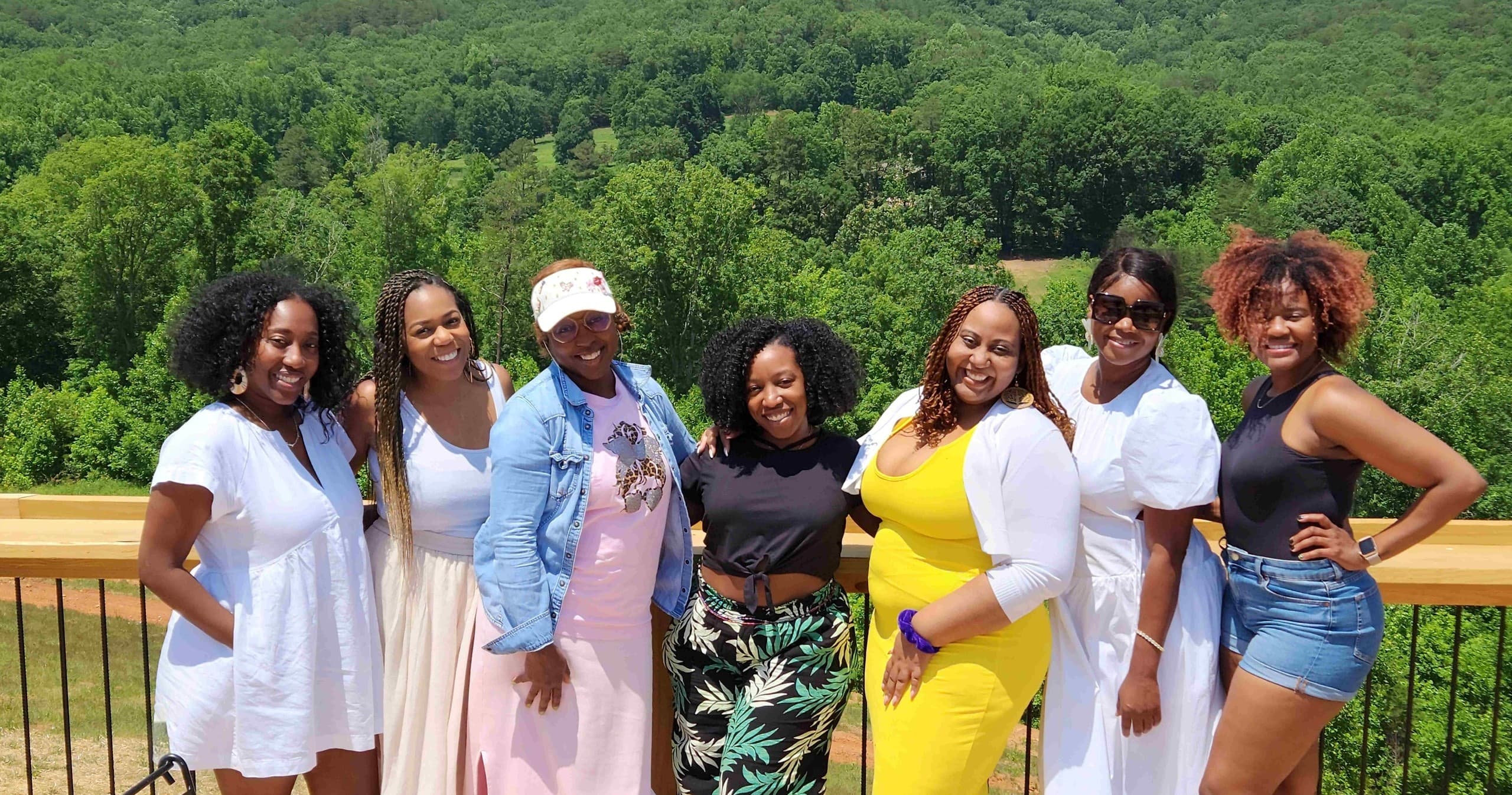 Group of friends on vineyard overlook deck with forest view