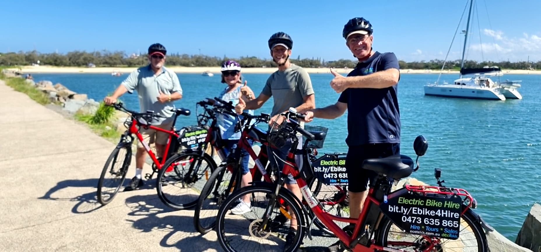 Group of cyclists by marina on sunny coastal bike tour