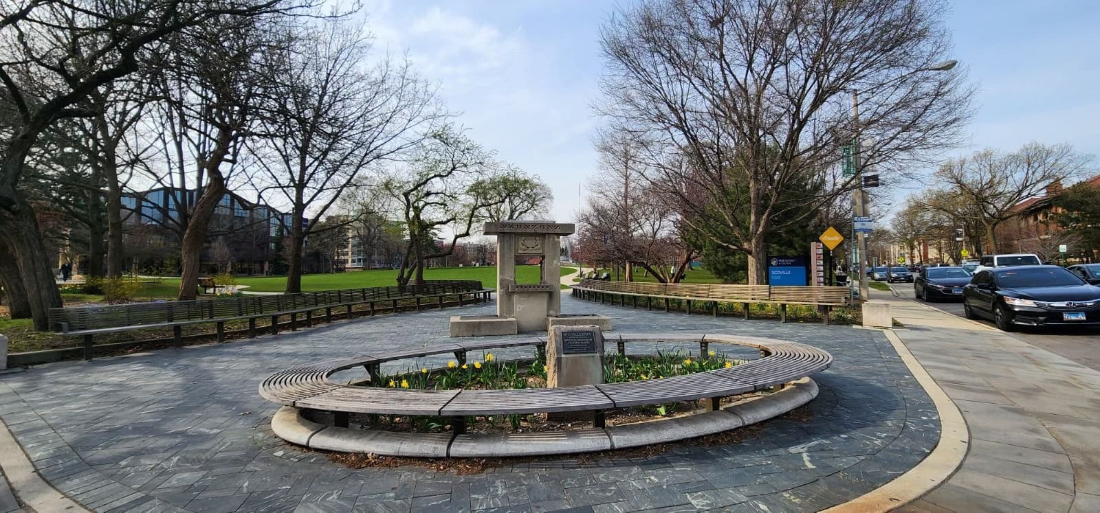 City park fountain in urban square with visitors strolling