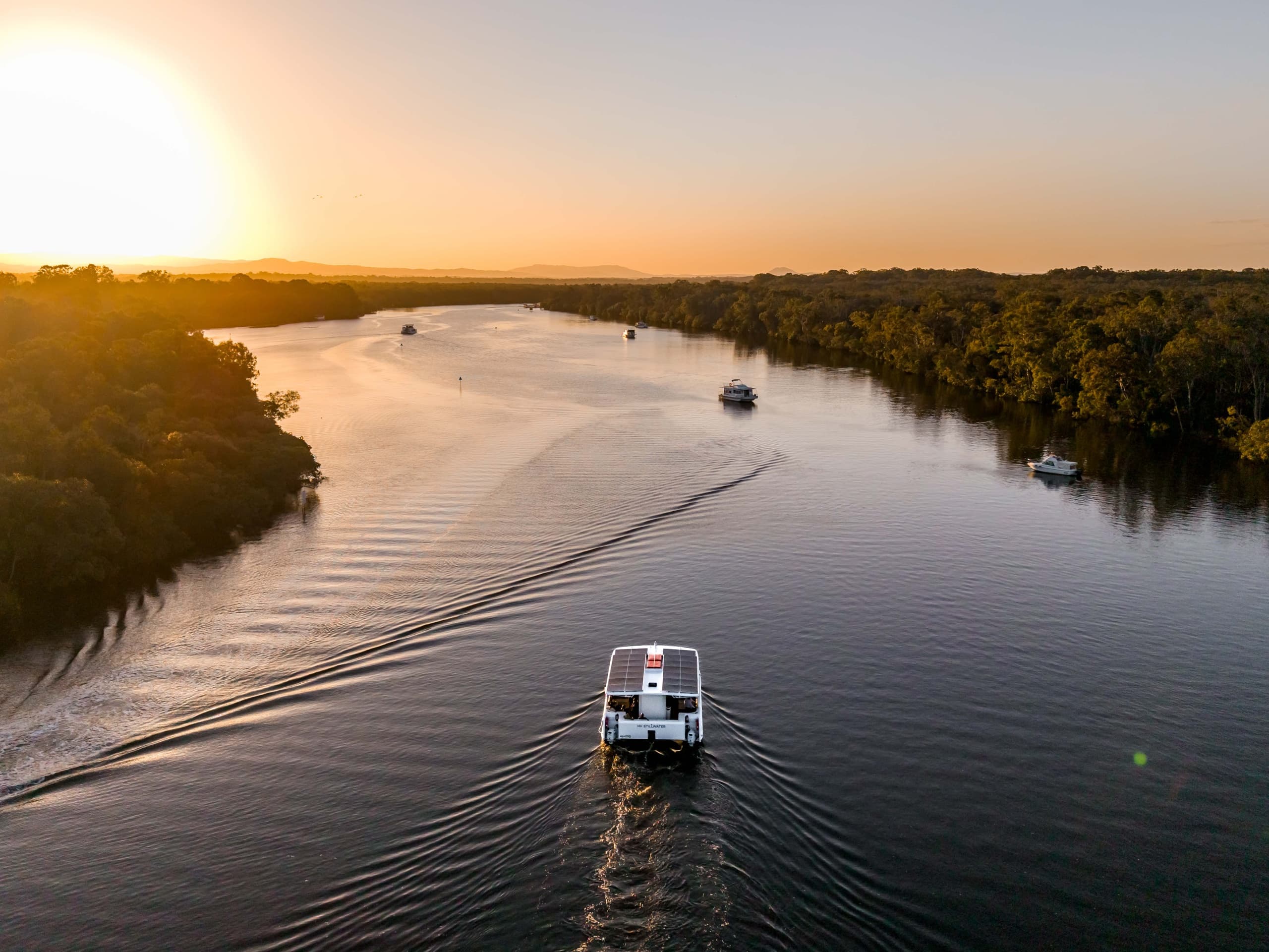 Ferry cruising Noosa River at sunset through scenic estuary