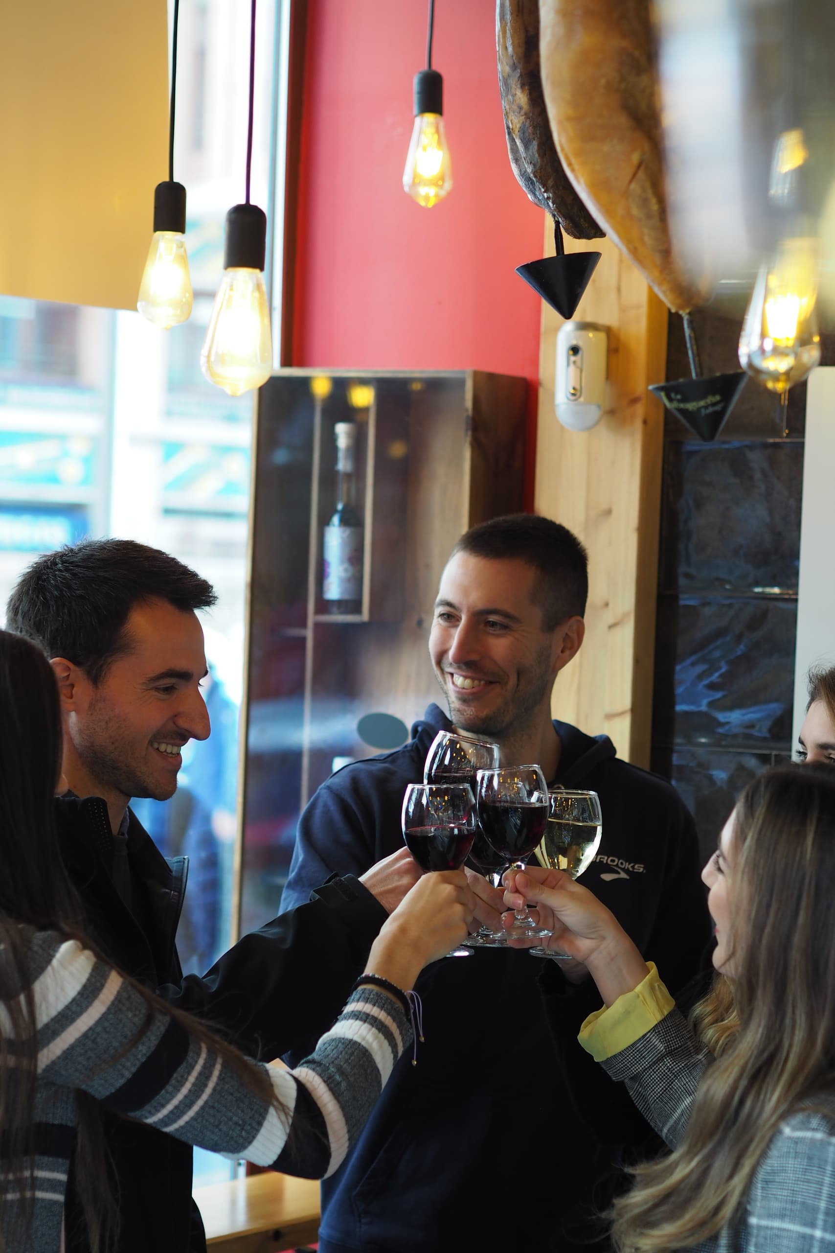 Friends clinking glasses in cozy Valencia wine bar on food tour