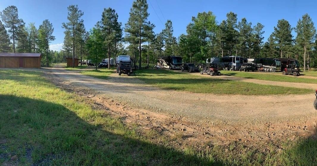 RV campground panoramic view among pine trees and grassy sites