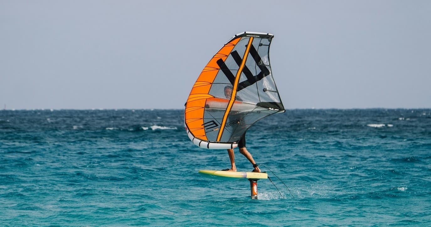 Foil windsurfer riding turquoise waves off Tarifa coastline