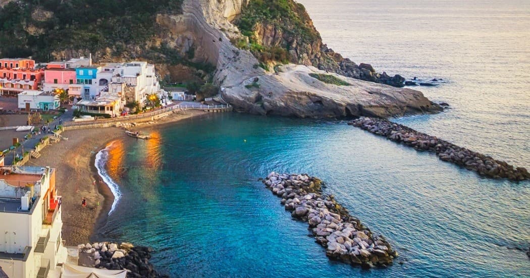 Scenic Amalfi cove with rocky jetty and crystal blue water