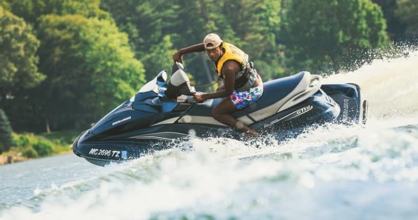 Jet ski carving fast through choppy lake water near shore