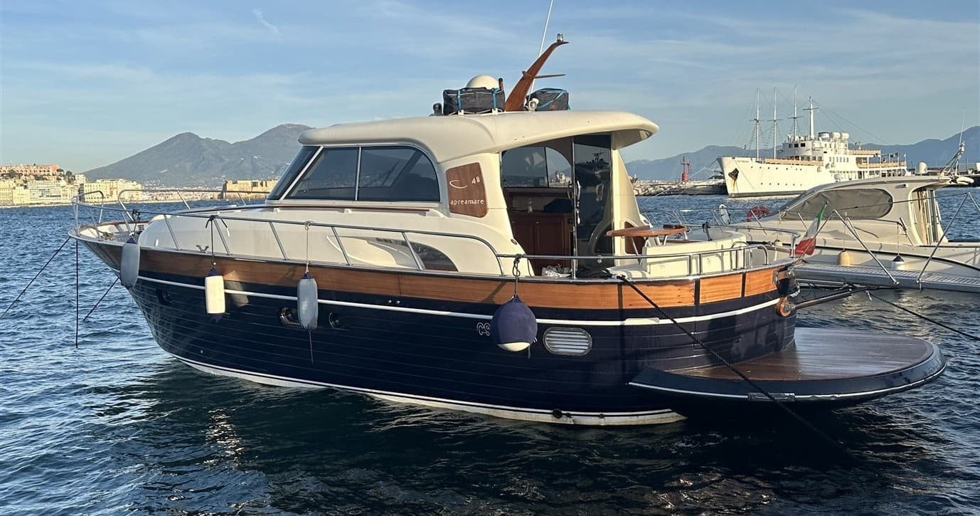 Classic wooden cabin yacht moored in harbor near coastal town