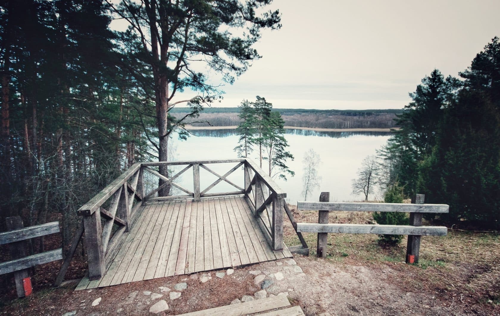 Lakeside wooden viewpoint overlooking forested lake vista