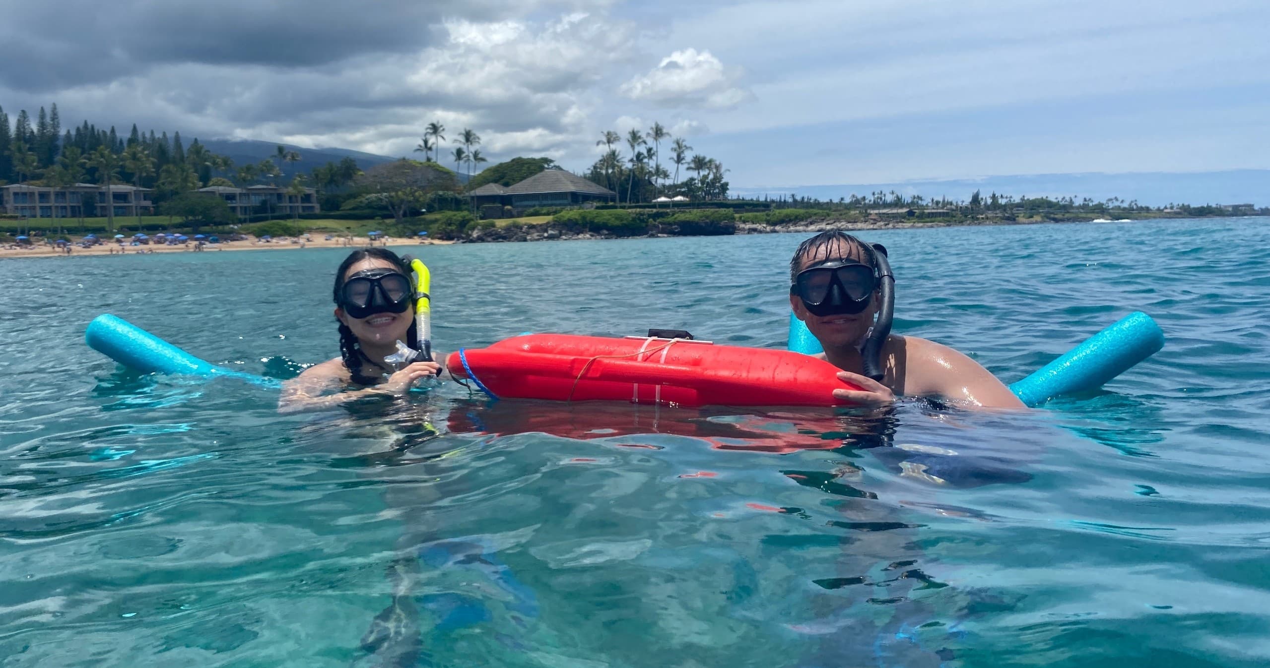 Two snorkelers floating with rescue buoy in Maui clear water