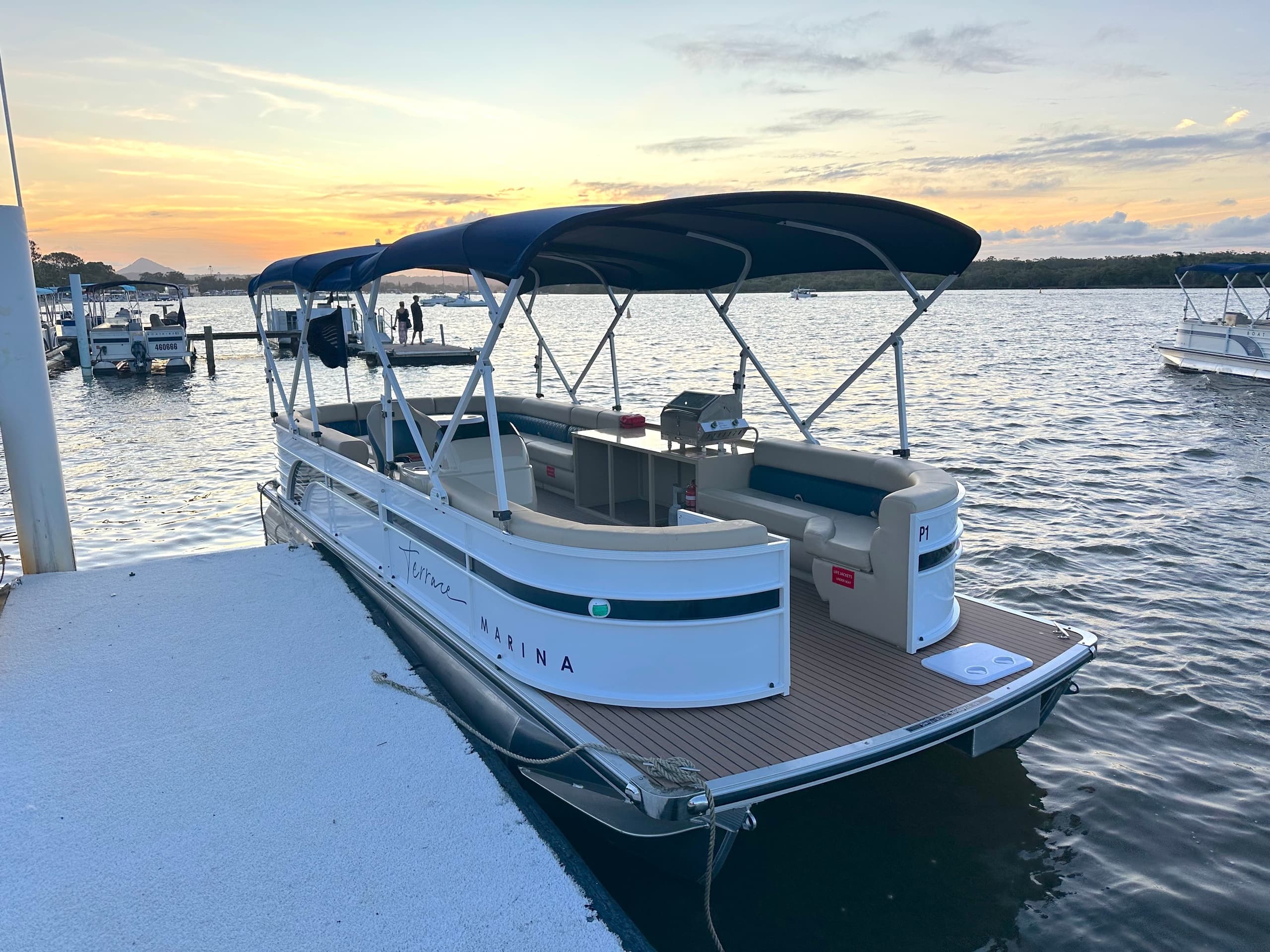 Pontoon boat moored at sunset on tranquil marina waterfront