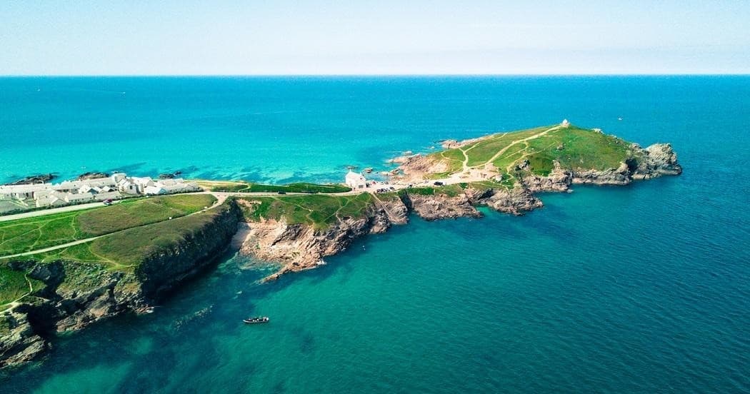 Aerial coastal headland over turquoise sea, dramatic scenic cliffs