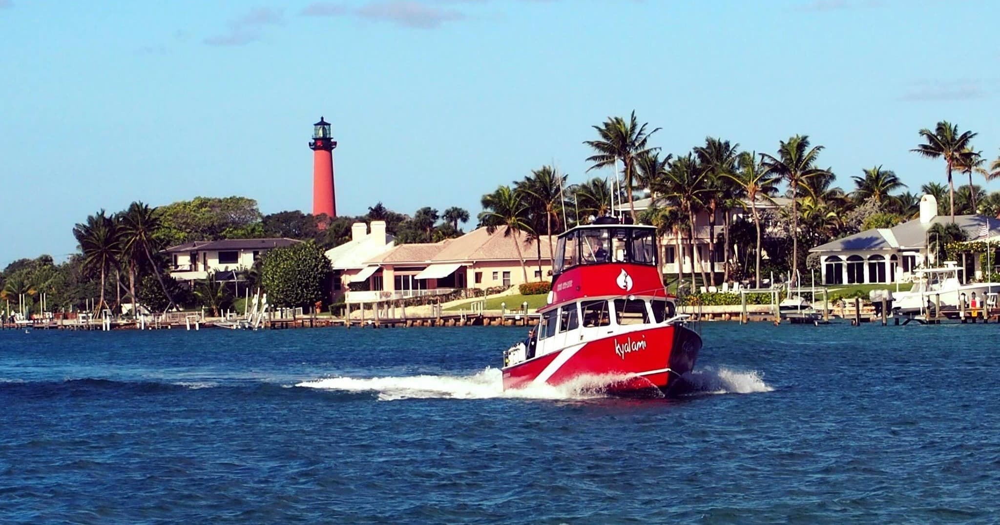 Fast rescue-style dive boat passing shoreline with lighthouse view