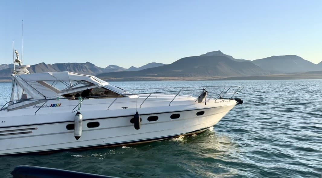 Luxury motor yacht cruising Arctic coastal waters near glaciers