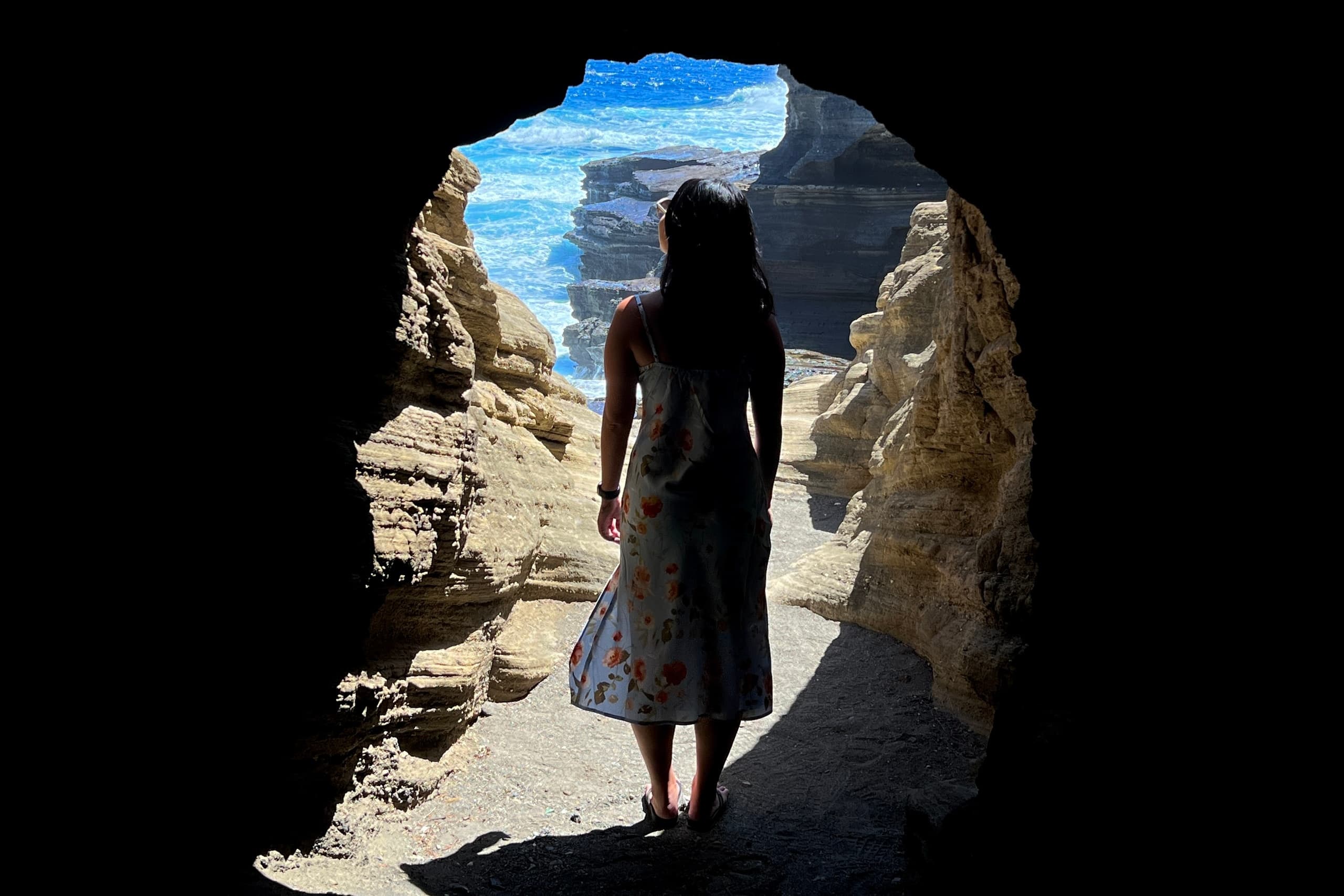 Cave exploration silhouette viewing ocean through sea arch