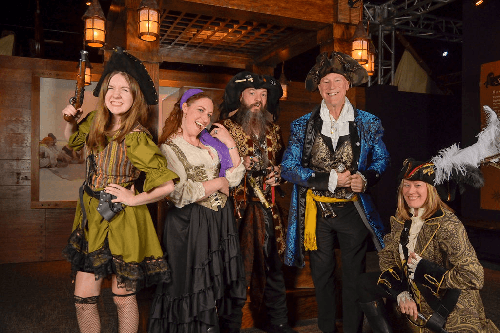 Costumed pirate crew posing in themed indoor pirate show experience