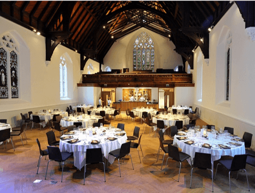 Banquet tables set for wedding reception in historic chapel hall