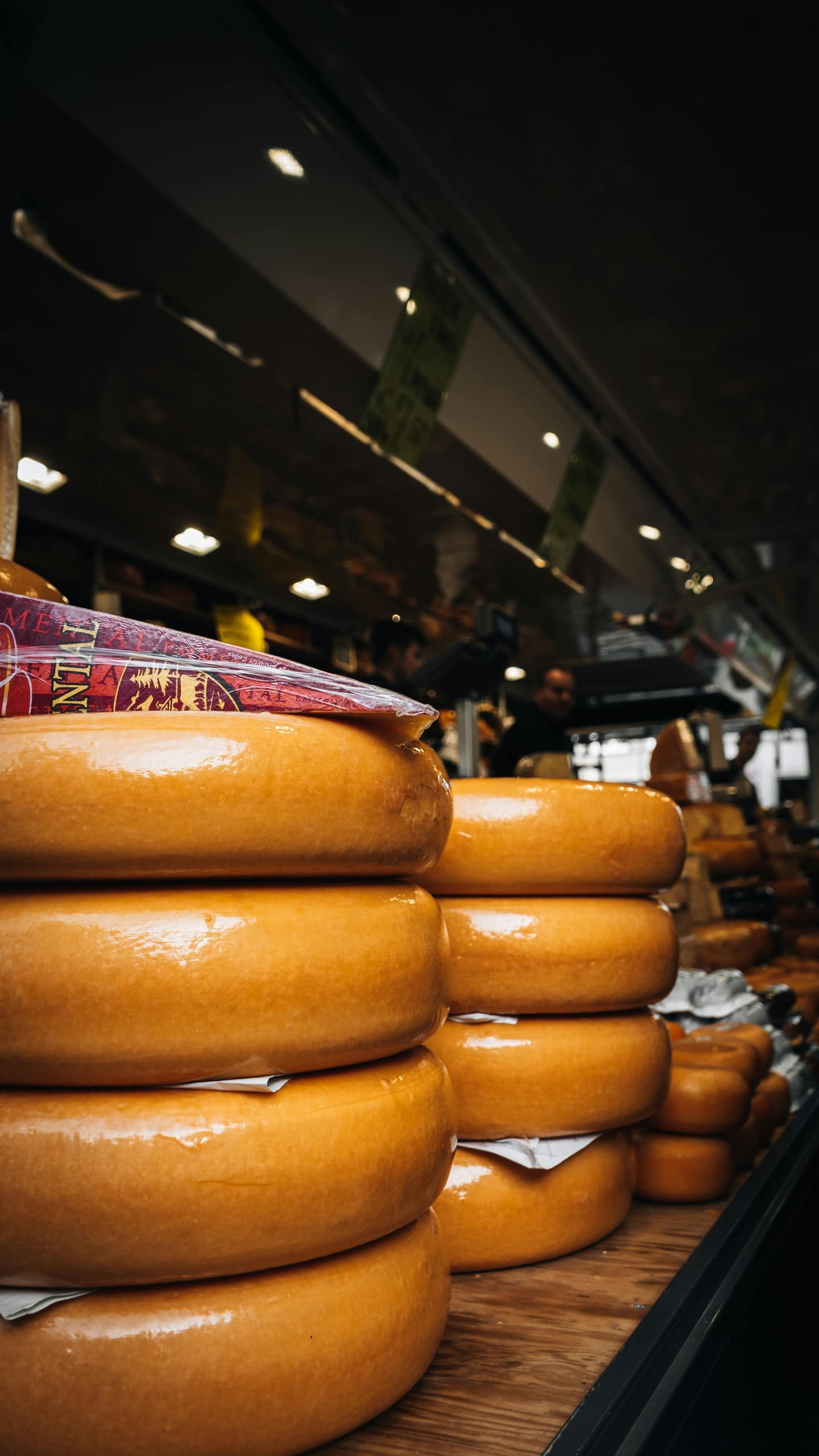 Stacked Gouda cheese wheels inside Amsterdam cheese market stall