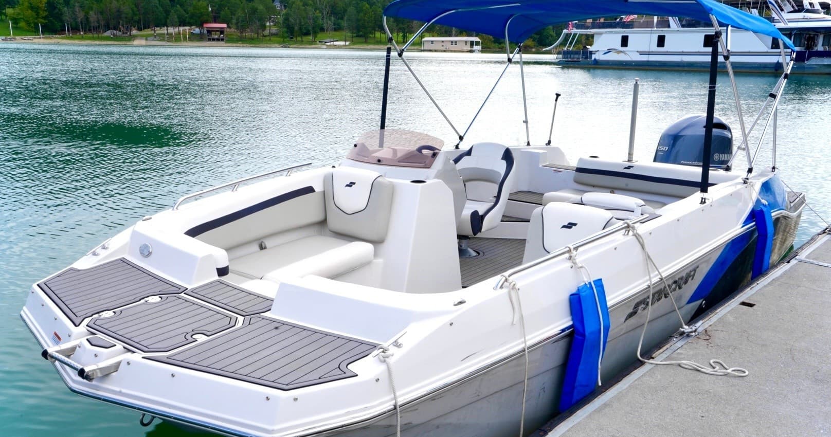 Bow view of white speedboat docked on calm lake water