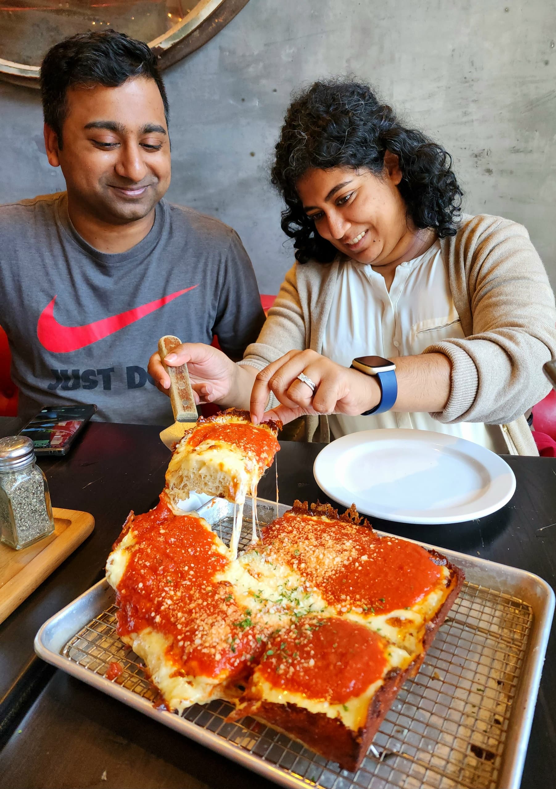 Couple sharing Chicago-style deep-dish pizza at restaurant