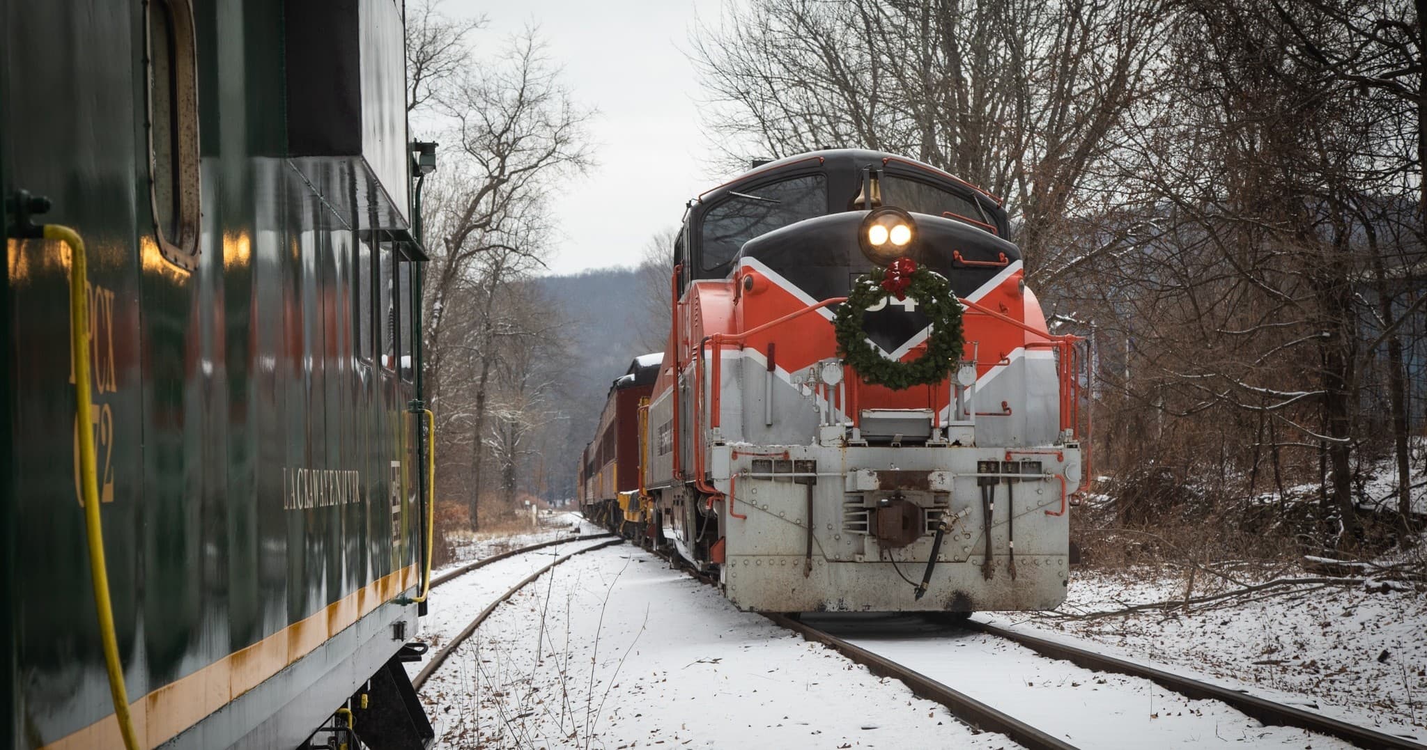 Vintage passenger locomotive plowing through snowy winter landscape
