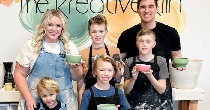 Family pottery class smiling with bowls in ceramics studio