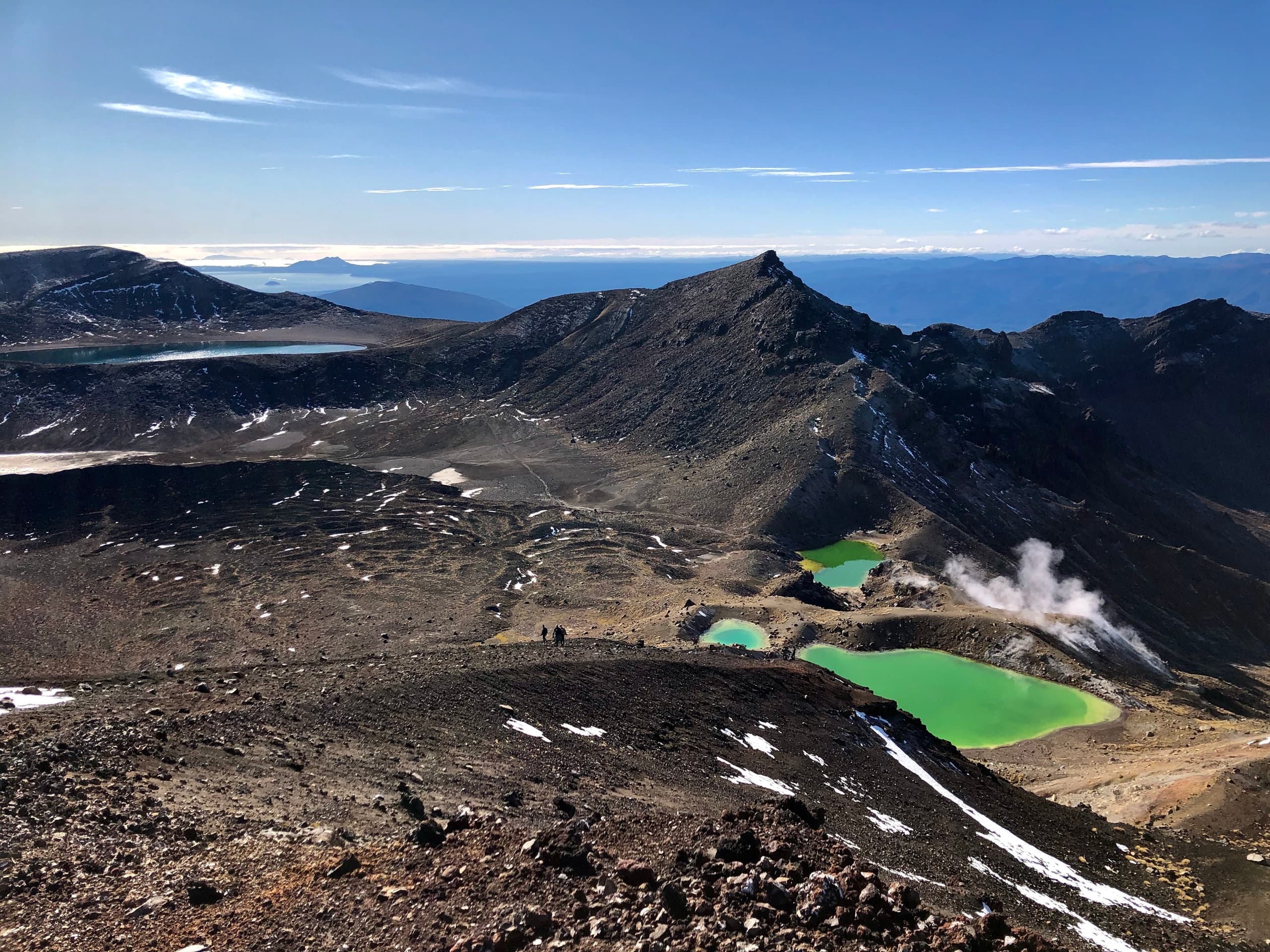 Aerial trail view of volcanic plateau and vivid emerald lakes