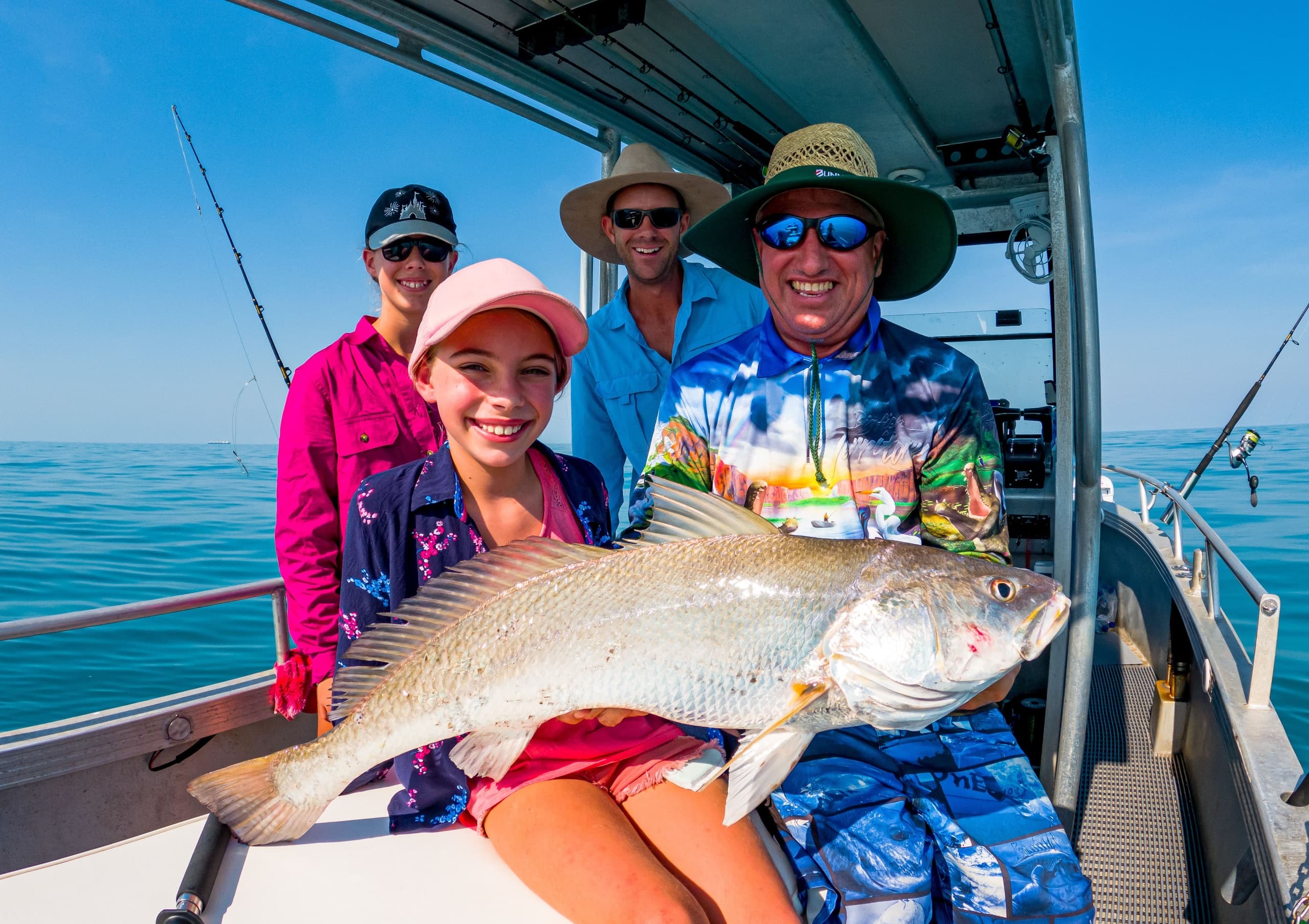 Group fishing charter posing with trophy fish on boat