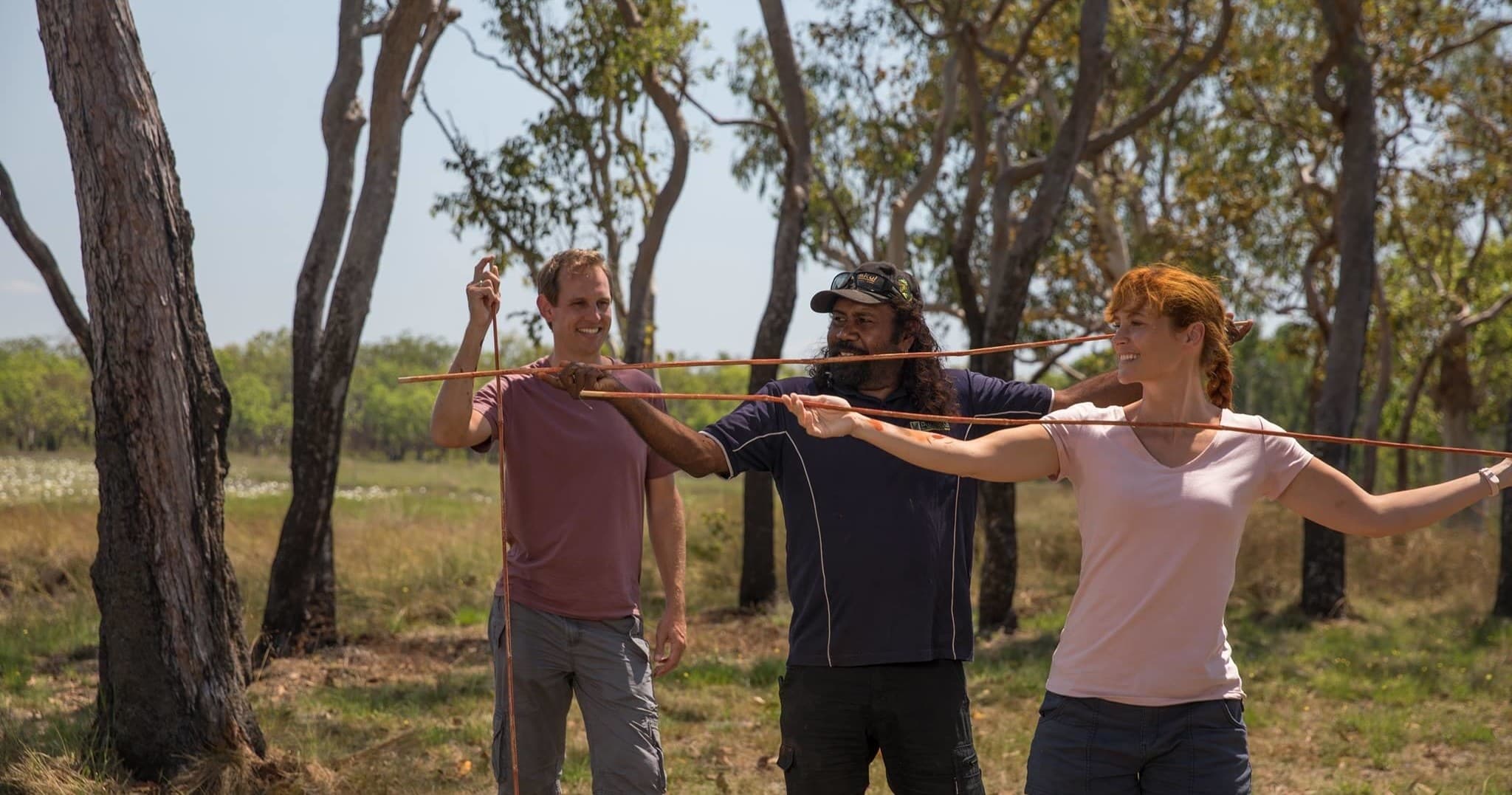 Group practicing spear-throwing in Australian bush outdoors