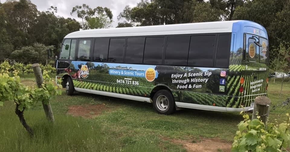 Winery shuttle parked among rows of vineyard vines for tour transport