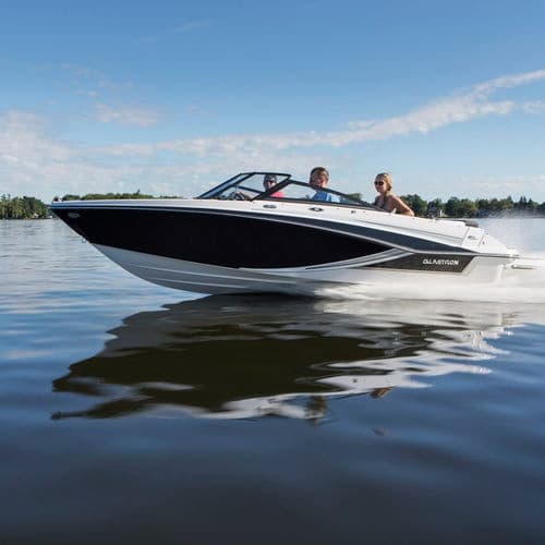 Speedboat cruising on glassy lake water under clear blue sky